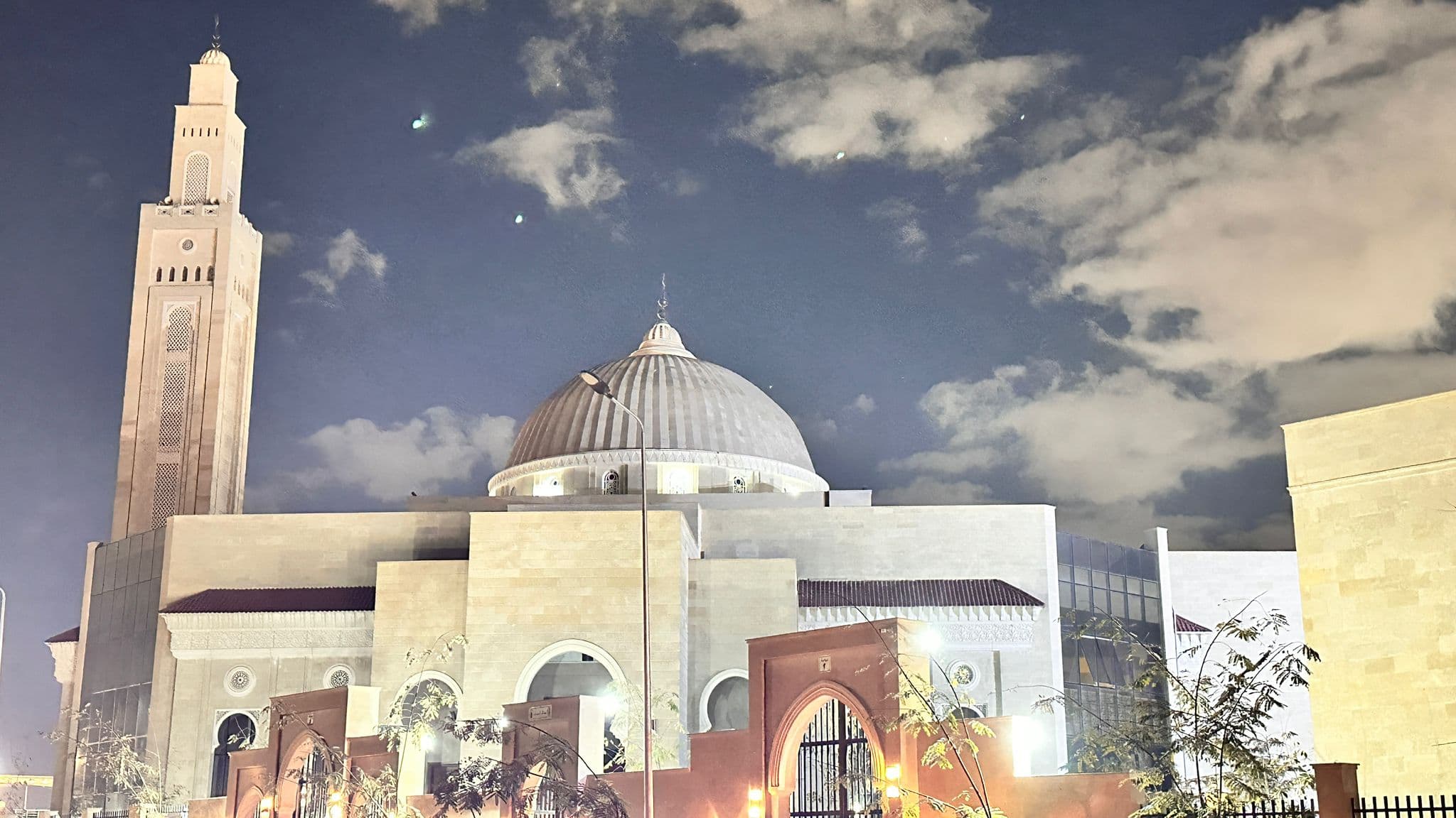 Masjid Al-Emam Al-Zahabi lit at night — dome and minaret